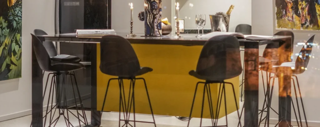 Apart Loft in Athens: yellow kitchen island bar with black high stools and artworks on the walls